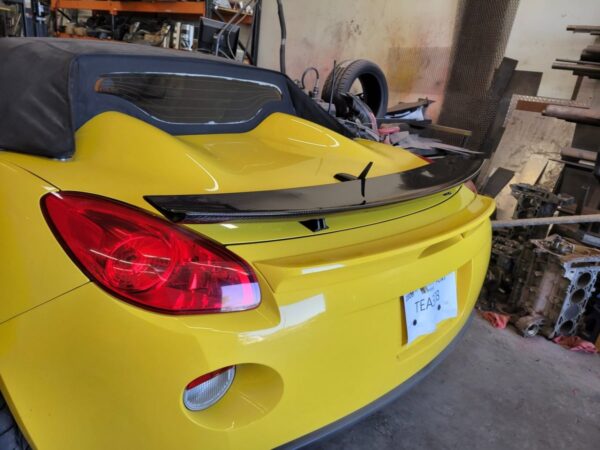 Carbon Fiber Spoiler for the Pontiac Solstice and Saturn Sky, shown installed on the trunk of a yellow Solstice.